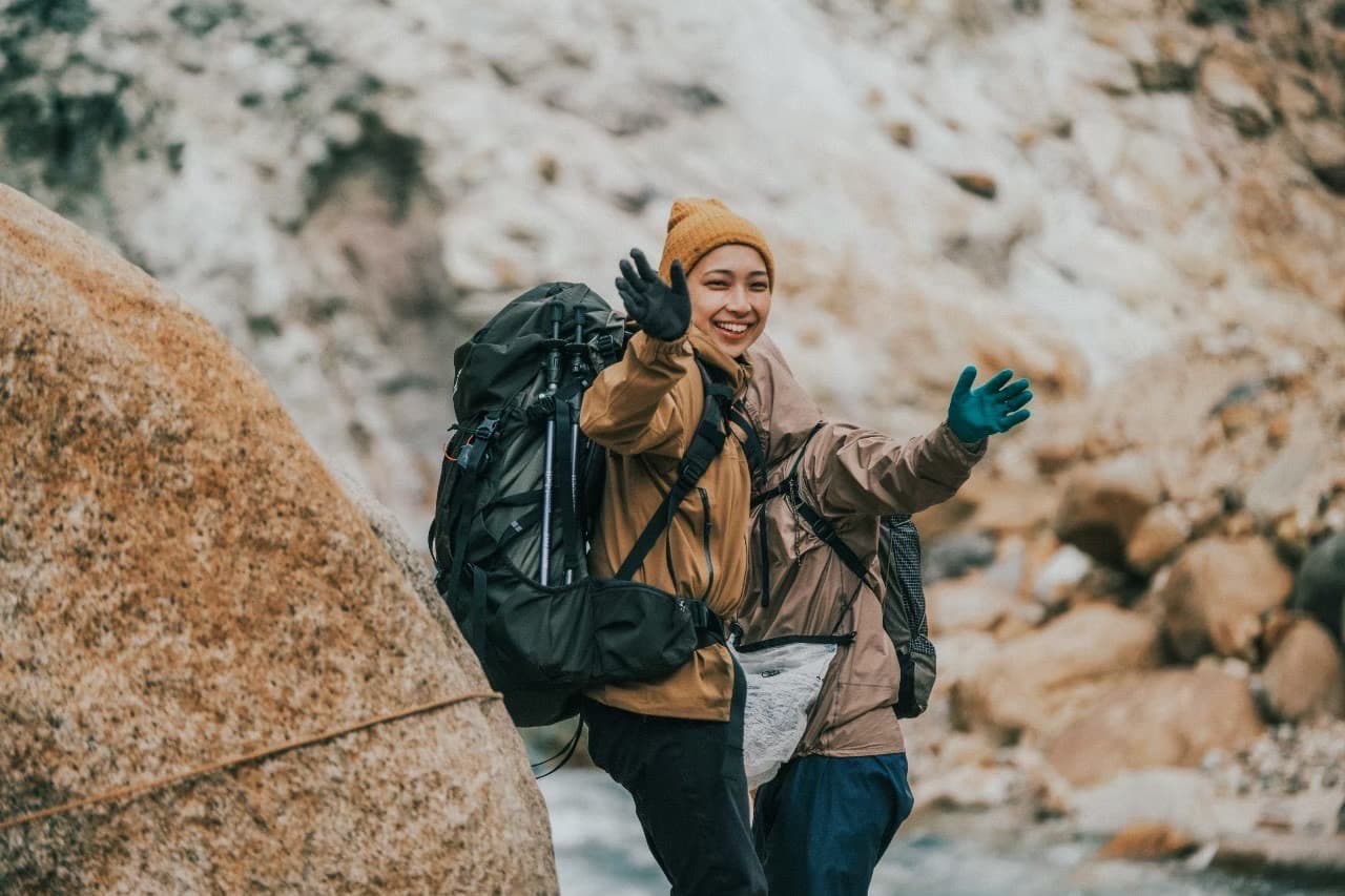 岩場で手を振る登山者
